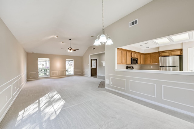 unfurnished living room with a decorative wall, a ceiling fan, visible vents, and light carpet