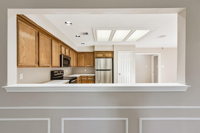 kitchen featuring visible vents, light countertops, appliances with stainless steel finishes, a peninsula, and brown cabinetry