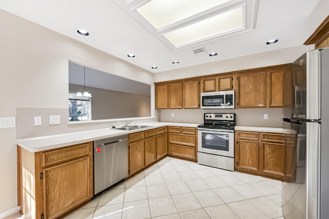 kitchen featuring light countertops, recessed lighting, appliances with stainless steel finishes, brown cabinetry, and a sink