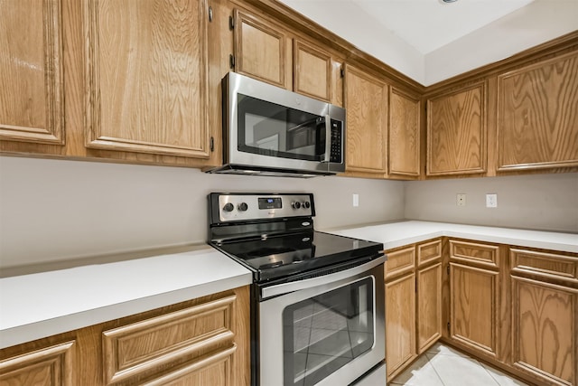 kitchen featuring brown cabinets, appliances with stainless steel finishes, and light countertops