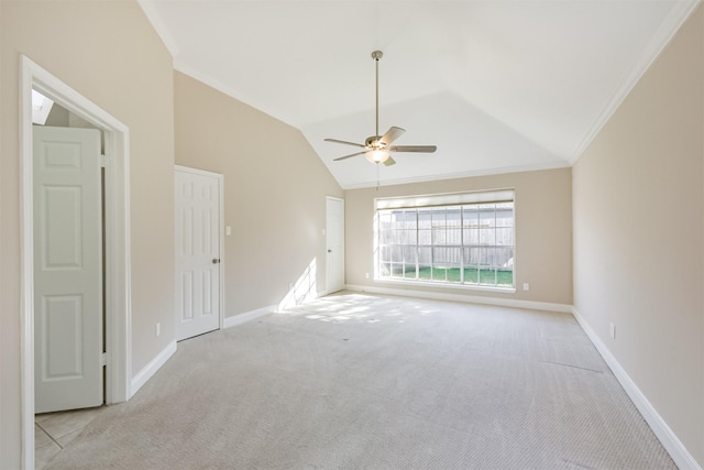 spare room with lofted ceiling, ornamental molding, a ceiling fan, carpet, and baseboards