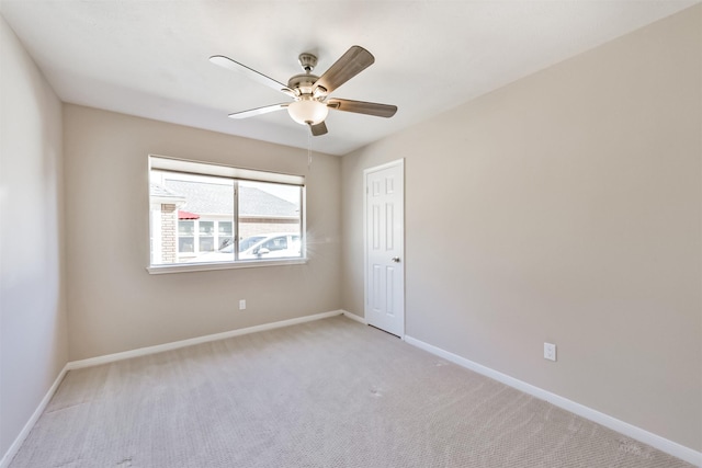 spare room with baseboards, light carpet, and ceiling fan