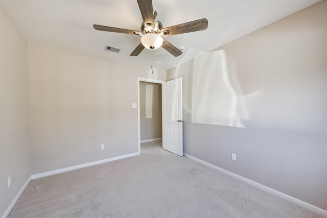 carpeted spare room with baseboards, visible vents, and ceiling fan