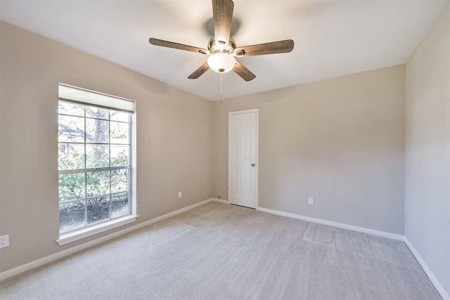 unfurnished room with baseboards, light carpet, and a ceiling fan