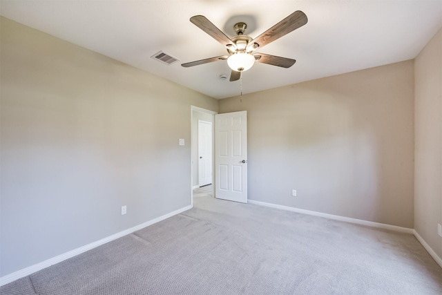 spare room featuring visible vents, baseboards, light carpet, and ceiling fan