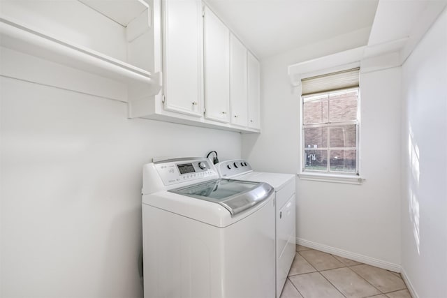 laundry room with light tile patterned floors, baseboards, cabinet space, and independent washer and dryer