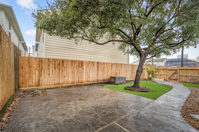 view of yard featuring a patio, a fenced backyard, and a gate