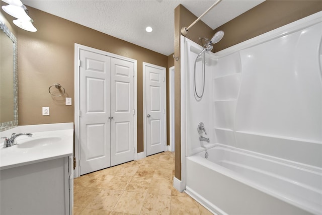 bathroom with tile patterned floors, shower / bathing tub combination, a textured ceiling, and vanity