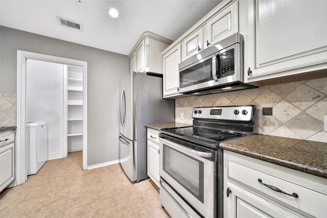 kitchen featuring tasteful backsplash, visible vents, washer and clothes dryer, light tile patterned flooring, and stainless steel appliances