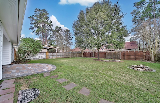 view of yard with a patio, a fenced backyard, and an outdoor fire pit