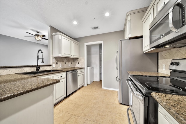 kitchen featuring visible vents, a sink, ceiling fan, stainless steel appliances, and backsplash