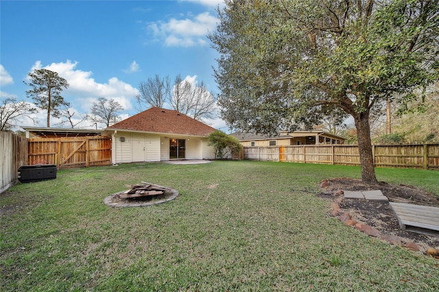 view of yard featuring a fire pit and a fenced backyard