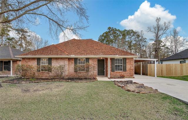 ranch-style house featuring a front lawn, fence, brick siding, and driveway