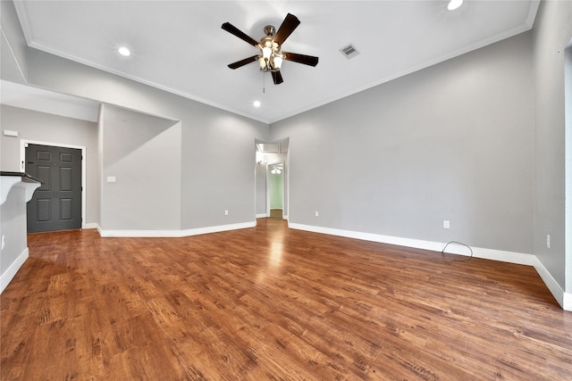 unfurnished living room with crown molding, wood finished floors, and baseboards