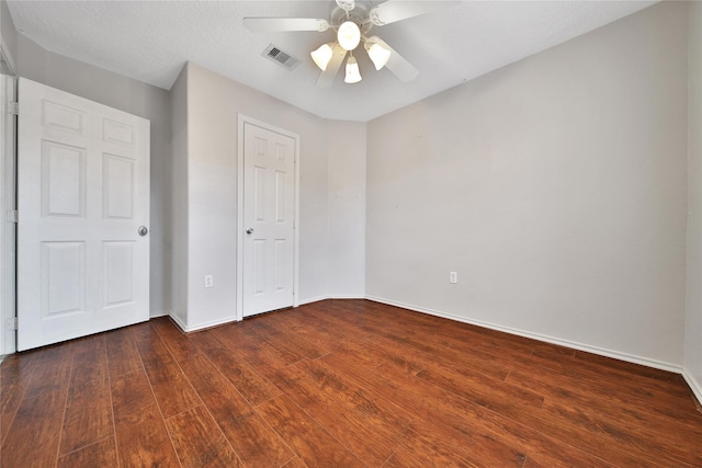 unfurnished bedroom featuring a ceiling fan, baseboards, visible vents, a closet, and wood-type flooring