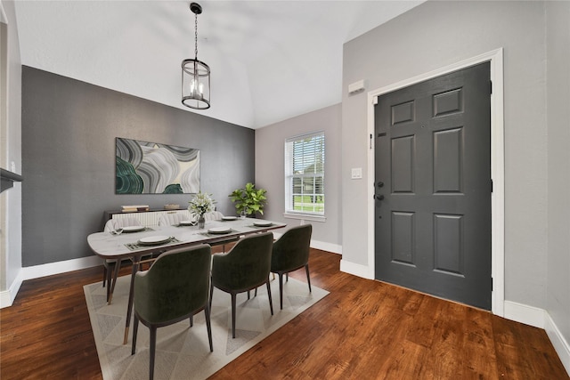 dining area featuring lofted ceiling, wood finished floors, and baseboards