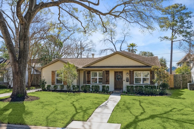 view of front facade featuring central AC unit, a front yard, and fence