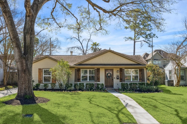 view of front of property with a front lawn, central air condition unit, and fence