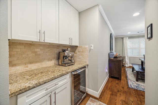 kitchen featuring wine cooler, tasteful backsplash, white cabinets, and crown molding