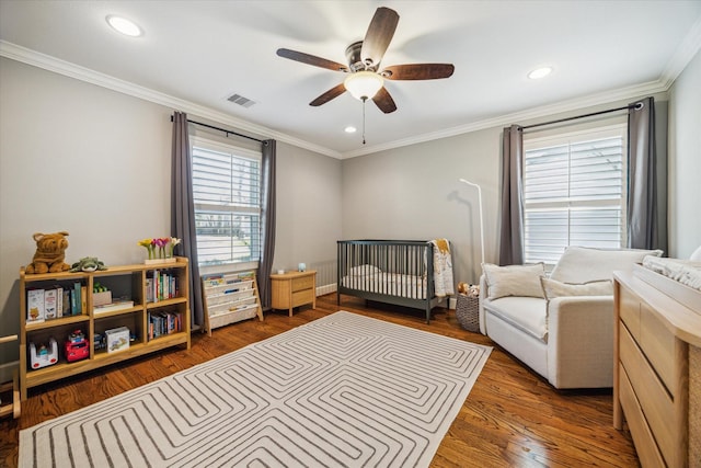 bedroom featuring crown molding, wood finished floors, and visible vents