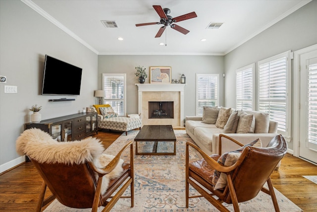 living room with visible vents, crown molding, baseboards, and wood finished floors