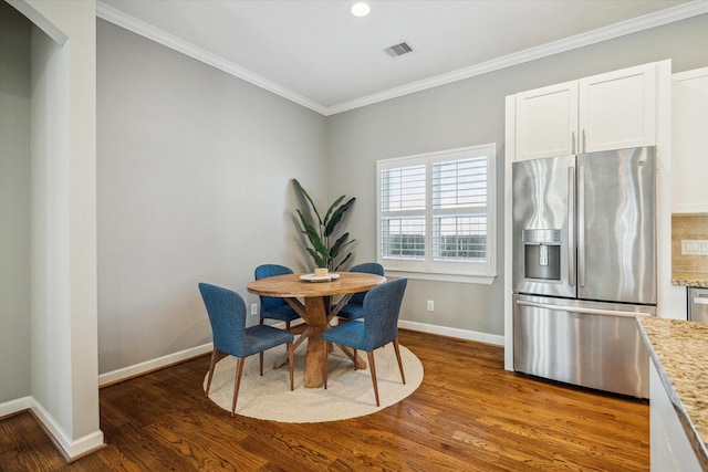 dining area with crown molding, wood finished floors, and baseboards