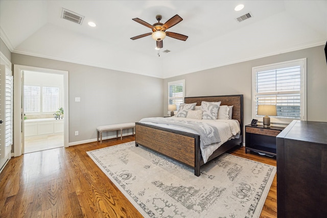 bedroom with visible vents, a raised ceiling, and wood finished floors