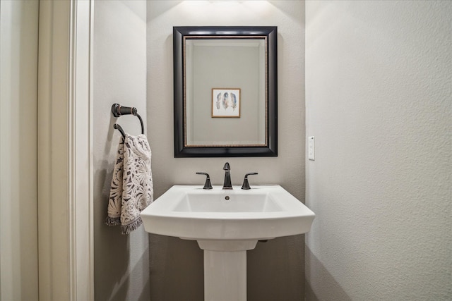 bathroom with a textured wall and a sink