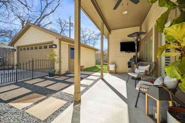 view of patio featuring a detached garage, an outdoor structure, and fence