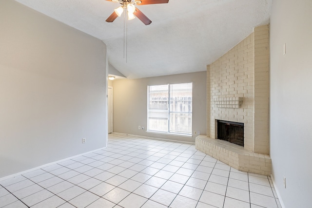 unfurnished living room featuring light tile patterned floors, a ceiling fan, lofted ceiling, a textured ceiling, and a brick fireplace