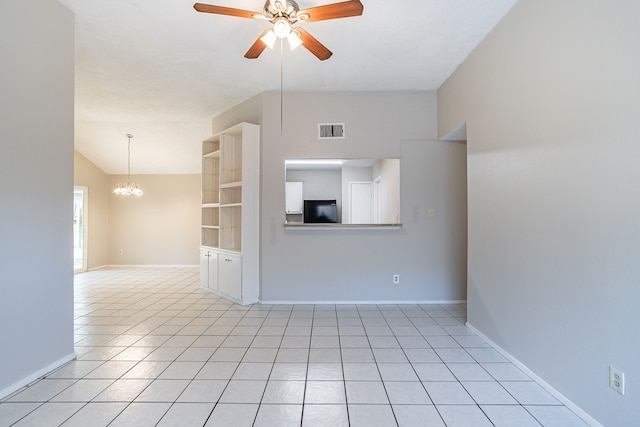 unfurnished room with visible vents, ceiling fan with notable chandelier, light tile patterned flooring, baseboards, and vaulted ceiling