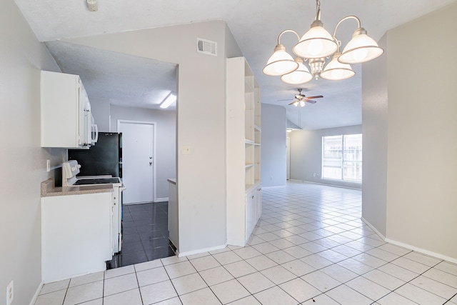 kitchen featuring visible vents, lofted ceiling, light tile patterned flooring, white cabinetry, and white electric range