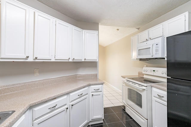 kitchen with dark tile patterned floors, white cabinets, white appliances, and light countertops