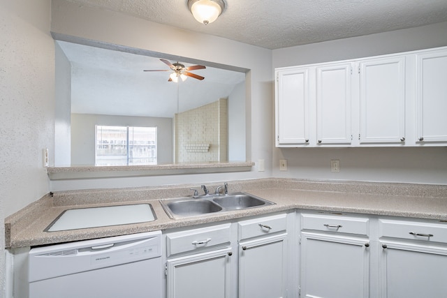 kitchen with a sink, light countertops, white cabinets, a textured ceiling, and dishwasher