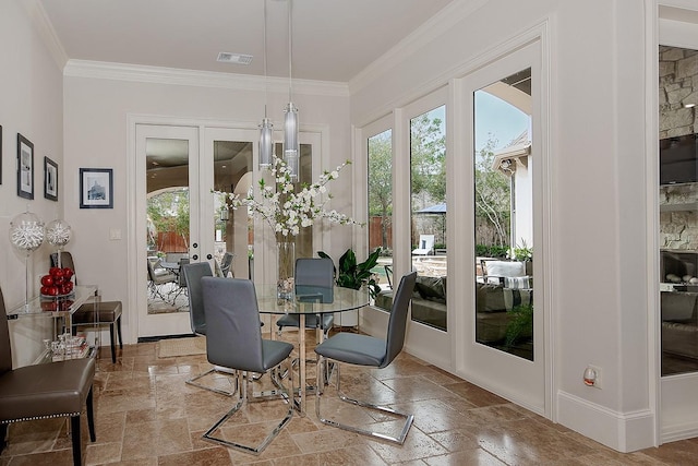 dining space featuring french doors, stone tile floors, crown molding, and visible vents