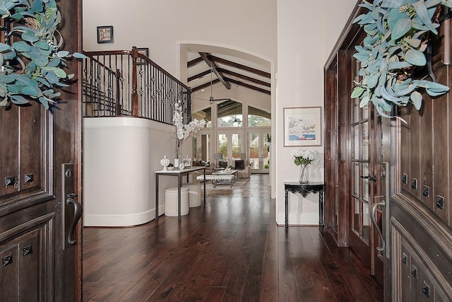 entryway featuring beam ceiling, high vaulted ceiling, baseboards, and dark wood-style flooring