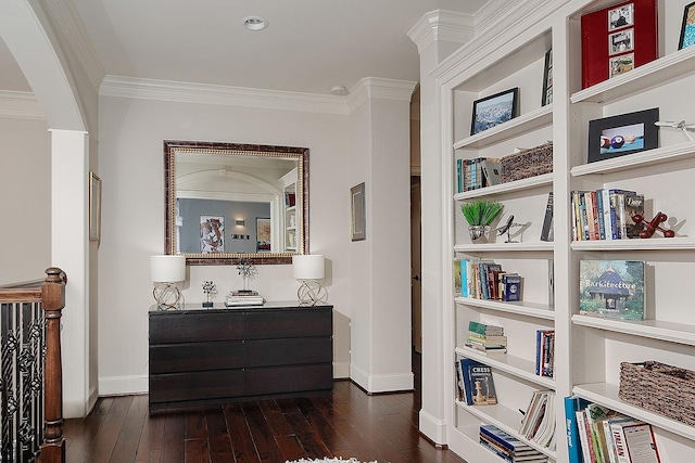 hallway with dark wood finished floors, crown molding, and baseboards