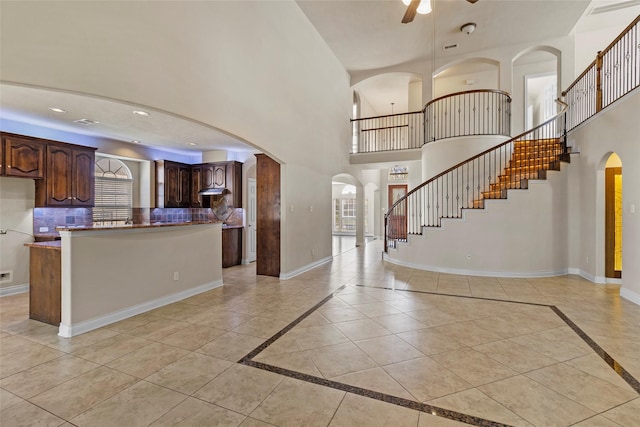 entryway with recessed lighting, baseboards, a high ceiling, and ceiling fan