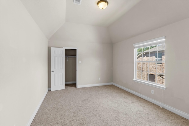 unfurnished bedroom with lofted ceiling, carpet, baseboards, and visible vents