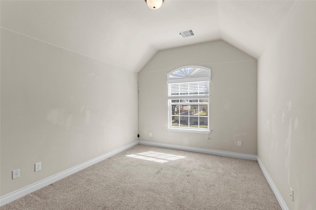 interior space featuring vaulted ceiling, carpet flooring, baseboards, and visible vents