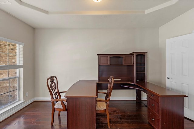 home office with a tray ceiling, baseboards, and dark wood-type flooring