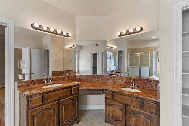 bathroom with a shower stall, double vanity, visible vents, and a sink