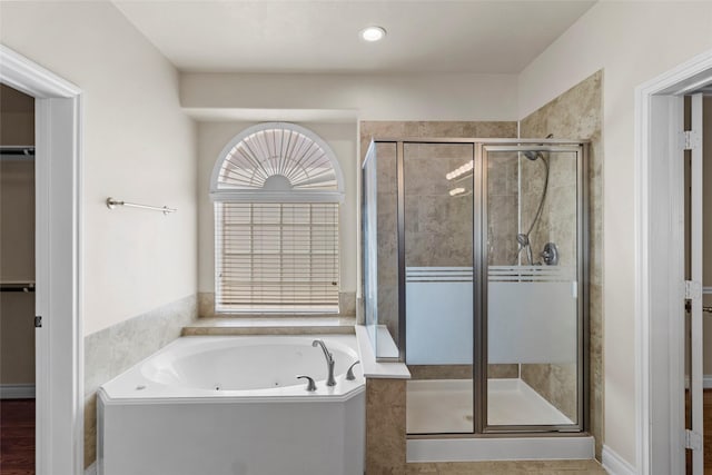 bathroom featuring a jetted tub and a stall shower