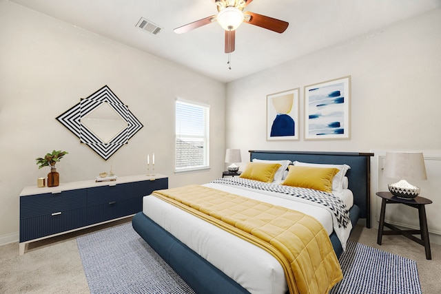 bedroom with visible vents, baseboards, light colored carpet, and a ceiling fan