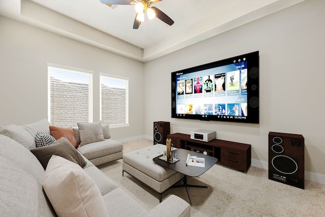 carpeted living room featuring a ceiling fan and baseboards