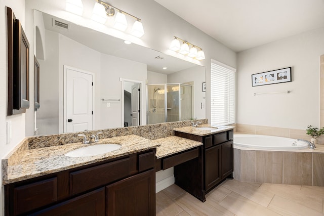 bathroom with vanity, a shower stall, a bath, and visible vents