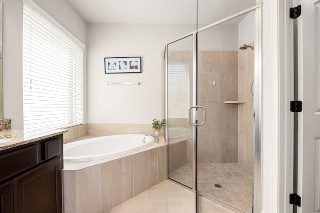 full bath with vanity, a bath, a stall shower, and a wealth of natural light