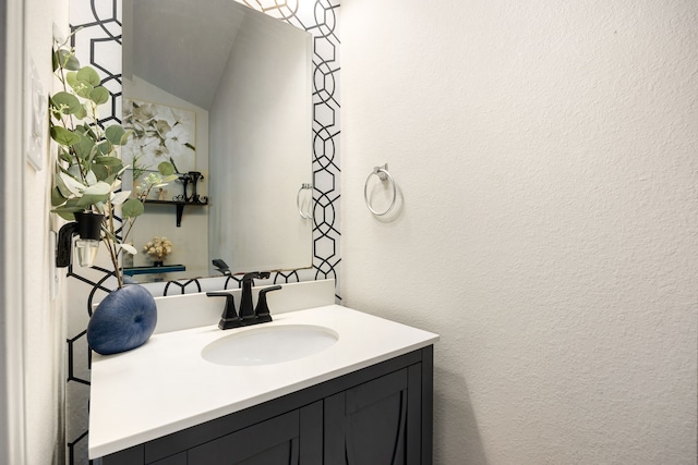 bathroom with vanity and a textured wall