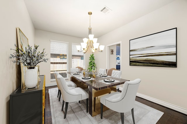 dining area featuring visible vents, baseboards, an inviting chandelier, and wood finished floors