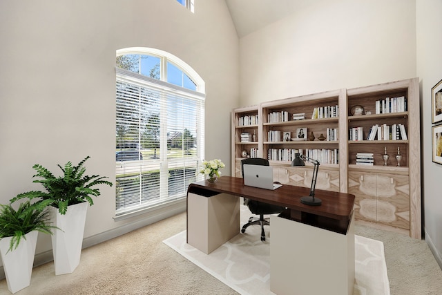 home office with light colored carpet and high vaulted ceiling